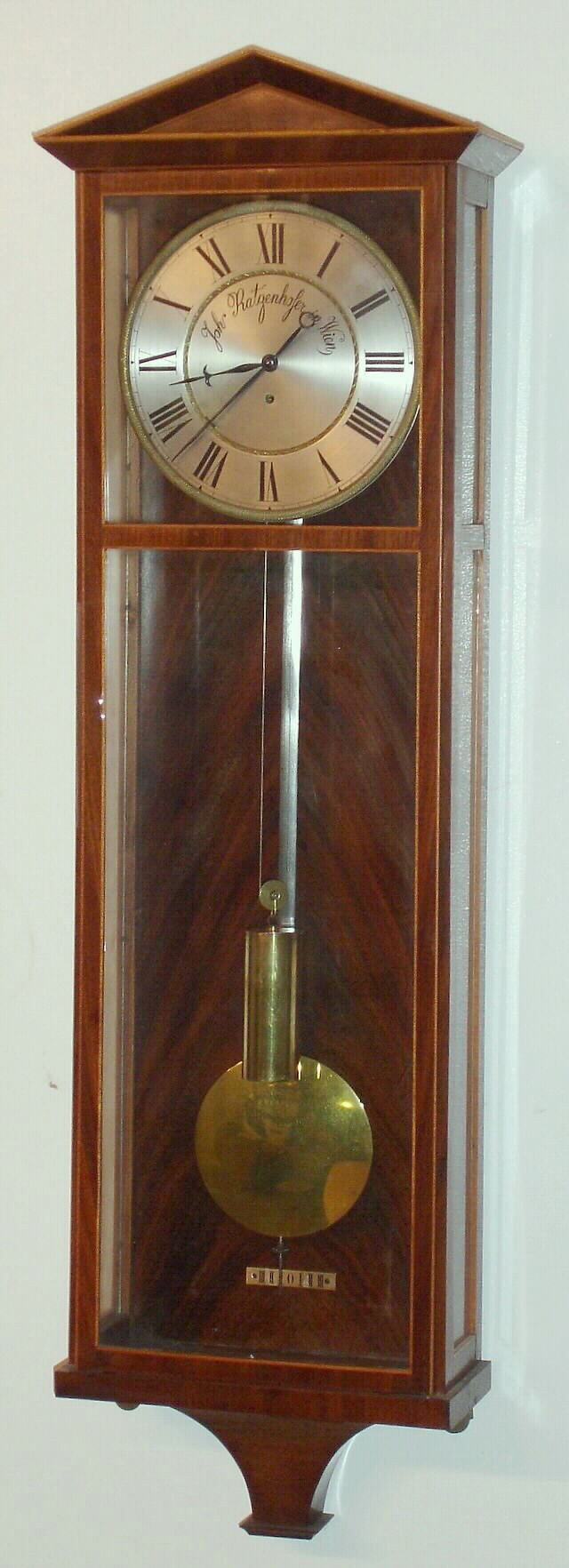 Austrian, Dachluhr timepiece, in a mahogany case with satinwood banding, and a pediment top. The two piece silvered dial has entire turned inner and outer bezels, 5 to 7 day duration, weight driven, silk thread suspension, c1825 — Antique Clocks Price Guide