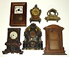 Six clock cases; one miniature ogee, one kitchen clock, two iron fronts (one with J.C. Brown dial), two fancy cast-metal. Largest is 19" tall