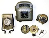 Four metal case specialty timekeepers. Oldest is C.1880 portable pocket watch watchman's clock, made in Germany. Sangamo "Tachograph" is automotive clock, speedometer and odometer, and is the largest at 8" tall. Swiss 13 jewel electric time switch is from Sauter, Basle. New Bridge with British Patent is cylindrical time switch with unusual month indicator.