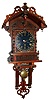 Presentation wall clock for "Kellog", special order probably from New Haven Clock Co., New Haven, Conn., 8 day time and calendar unsigned spring driven movement in ornate walnut case with turnings, finials, cutouts and carvings and black dial with gold numerals painted directly on the case, c1880