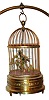 Single singing bird in cage manufactured by Karl Griesbaum, Triberg, Germany with mechanical movement imparting motion to bird on perch including brass stand for larger size bird cage, c1950