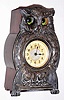 Owl novelty clock German or Swiss with moving eyes and cast white metal front inset with Arabic numeral dial all on wooden housing for movement, c1920