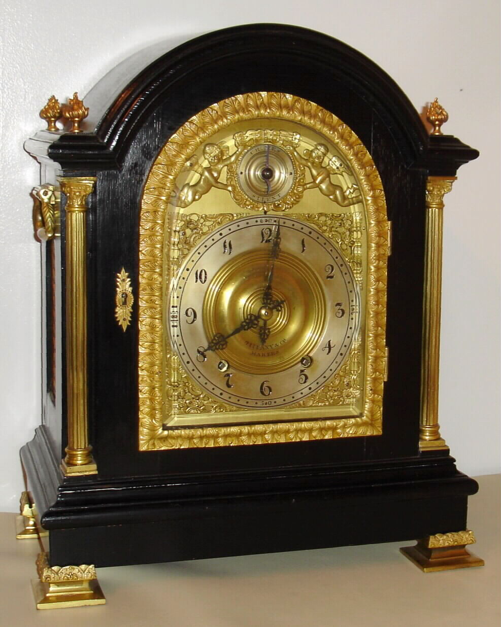 Tiffany and Co., New York bracket clock, 8 day, time, strike and Westminster chime, spring driven movement in an ebonized oak case with gilded cast door frame and beveled glass. The brass dial is marked "TIFFANY and CO. MAKERS" and has a silvered chapter ring and applied brass spandrels and cherubs, c1890 — Antique Clocks Price Guide