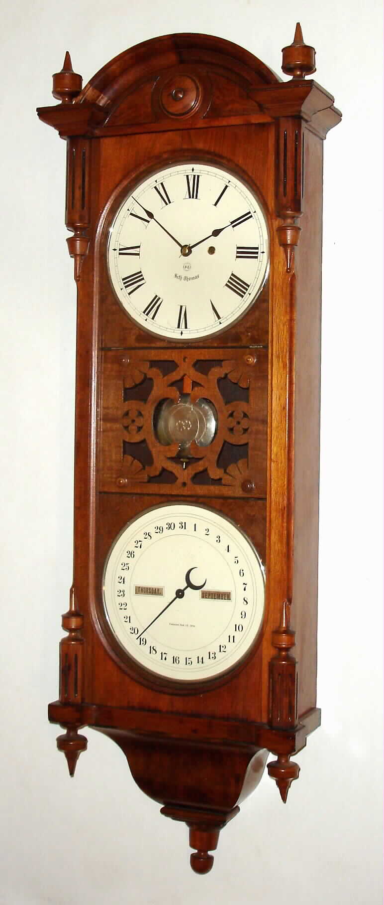Seth Thomas Clock Co., Thomaston, Conn., "Office Calendar No. 10" earlier version with fret work between the two dials, 8 day, time and perpetual calendar, weight driven movement in walnut case similar to the "Regulator No. 6" with painted metal double dials, c1886 — Antique Clocks Price Guide