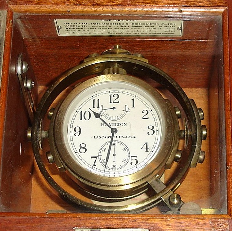 Hamilton Watch Co. Model 22 deck watch with 48 hour wind indicator 35S 21J, stem wind, pin and pendant set, Adj to Temp and 6 pos, parallel line damascene nickel movement with lever escapement and micrometric regulator. The Arabic numeral silvered metal dial has blacked steel hands. The movement is housed on gimbals in mahogany box with "HAMILTON WATCH CO LANCASTER, PA., U.S.A." tag, s#2F2008 — Antique Clocks Price Guide