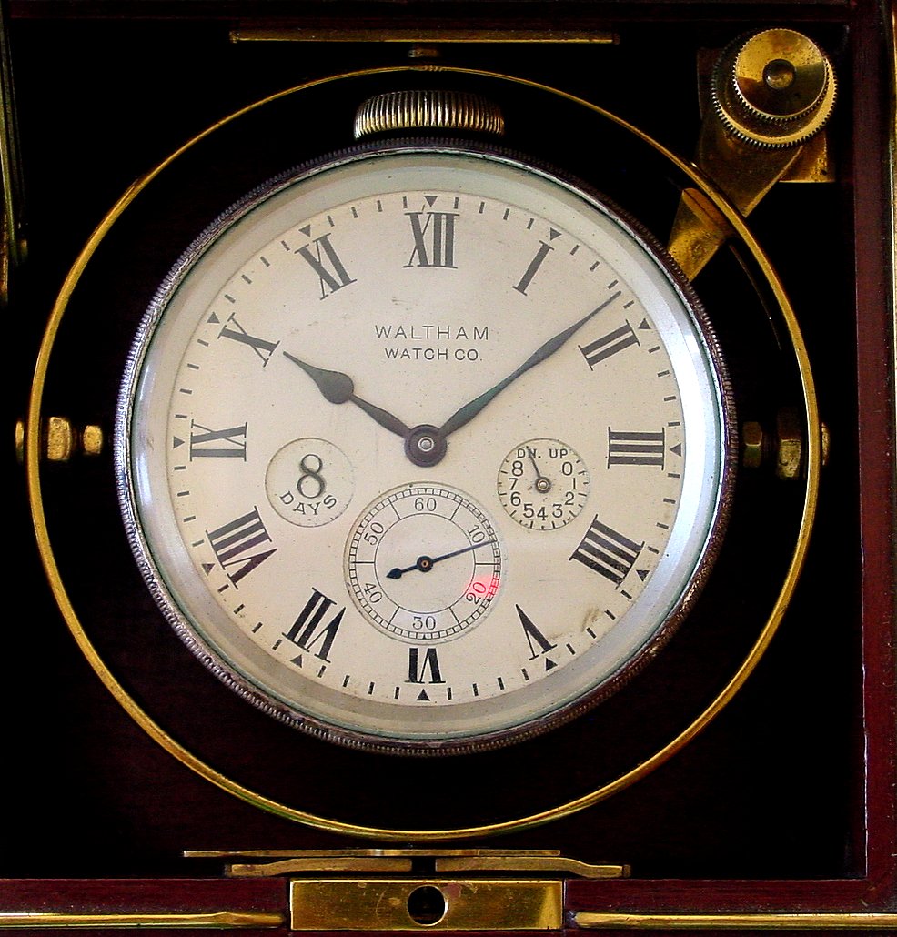 American Waltham Watch Co deck watch, 8 day duration with wind indicator 35S 15J, stem wind, pendant, set, adjusted, damascene nickel movement with lever escapement and Roman numeral silvered metal dial with subsidiary seconds at 6 and an inset "8 DAYS" emblem all housed in brass case with base metal coin edge bezel set on gimbals in a mahogany box with two metal tags reading "WALTHAM", s#22228667 — Antique Clocks Price Guide
