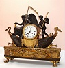 French, Love and Time, Bronze and Marble mantle clock, depicting Father time or Chronos with his scythe, sitting in a boat, steered by the cherubic Amor, and with a quality movement by Vincenti (1855 award medallion), the bronze boat and "water" mounted to a well figured piece of yellow / black striped marble, the whole supported on 4 large paw feet, c1875.