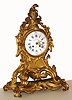 French mantel clock for Ch. Levassort, in the Louis XV style, 8 day, time and strike, spring driven movement in an ornate ormolu case with floral decor and white enamel dial, the main case with an integral base, c1880