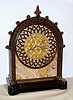 E.F. Caldwell, New York mantel clock with E. Howard and Co., Boston, 8 day, time only, spring driven, nickel damascene movement with lever escapement and is housed in a very heavy marble case with intricately cast Gothic style bronze case trim resting on conforming ebonized wooden base. The cut brass chapter ring has nickel plated Roman numerals and hands, c1915