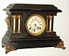 Loheide Mfg. Co. Wizard Clock Trade Stimulator, nickel play. Loheide Mfg bought the "DeSoto" black mantel clock from Waterbury and modified it to dispense chits for redemption. At the turn of the last century, trade stimulators were common throughout the US in cigar stores, confectionaries, general stores, and just about any other point of sale location. The logic is as follows: say you stopped at the corner store for eggs, as that was all you needed. Seeing this clock, there might be a sign touting "win two packs of gum for the price of one, 5 cents". Now you don't need the gum, but the thought of getting 2 for one is irresistible, so nearly every patron would drop in his nickel and get at least a chit for one pack of gum [the standard retail transaction]. A small percentage of patrons got two packs, and were always noisy about it, adding to the excitement, c1907