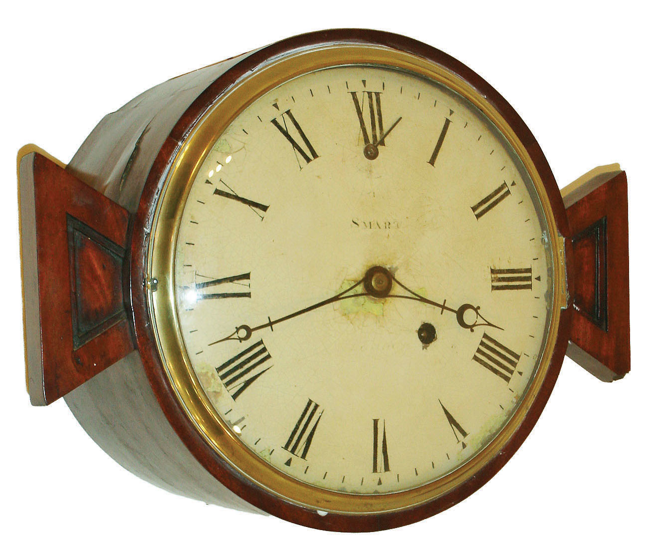 English mahogany barrel form 8 day, fusee spring brass movement wall clock or timepiece, c1815  The dial is signed "Smart",  who might possibly be Benjamin Smart a London clockmaker who worked from 1797-1818 located at 35 Firth Street.  The two "ears" would suggest that this timepiece may have been built into some larger structure.  There are three holes in the case at the six o'clock position that would suggest this timepiece was mounted onto a stand with three pins. — Antique Clocks Price Guide