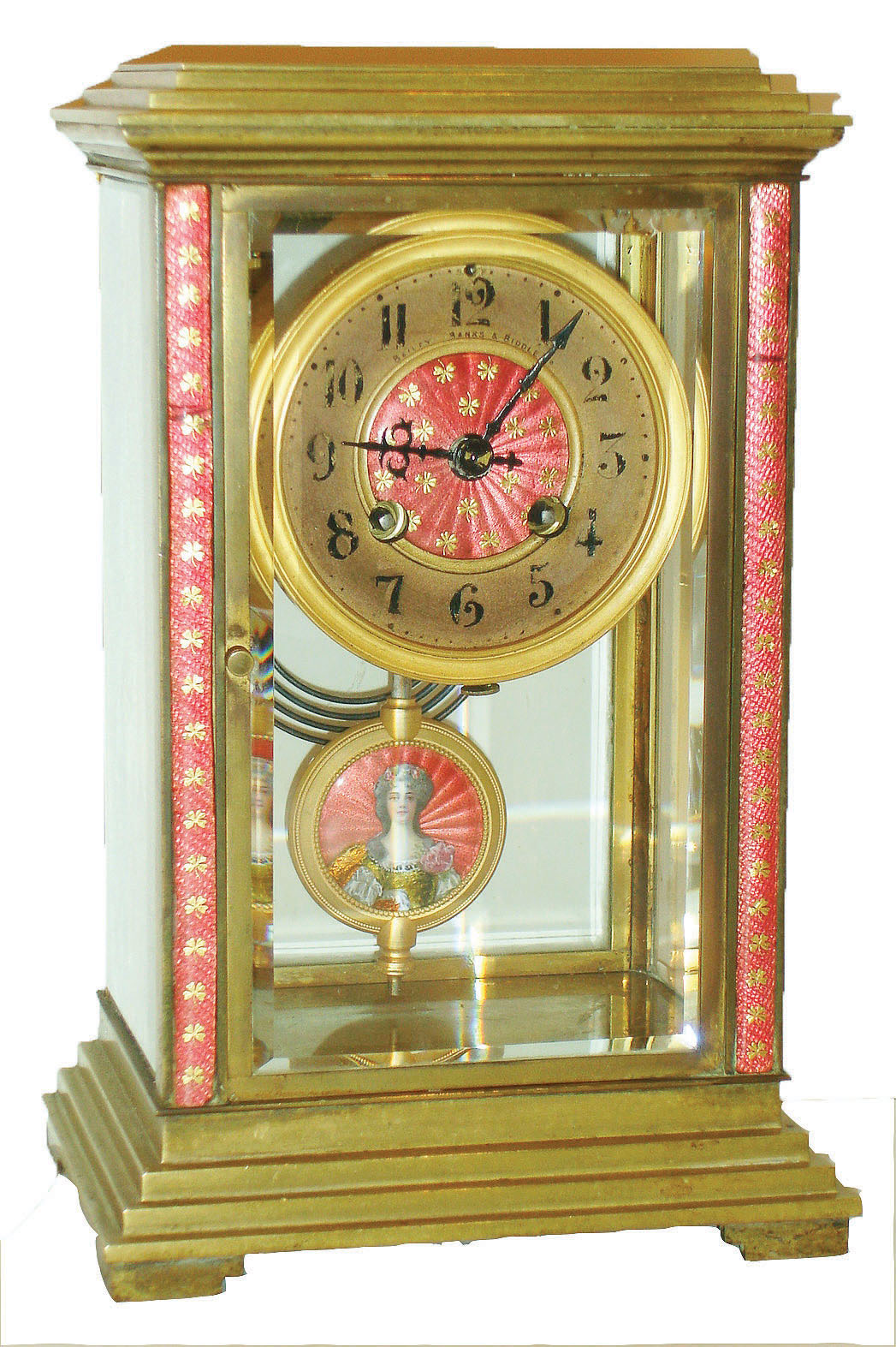 France, crystal regulator, brass case with stepped base and top and with beveled glasses, the case front and dial center decorated with pink champleve enamel, the enamel ornamented with gilt shamrocks, gilt bezel, Arabic numeral gilt metal dial marked "Bailey, Banks & Biddle Co.", 8 day time and strike pendule a Paris movement with Brocot escapement, the mark of Japy Freres, and also marked A1, striking on a gong, gilt pendulum with pink champleve enamel with portrait of a stylish young woman painted with opaque overglaze enamel, her dress in transparent orange and yellow enamels and backed with foil, c1910 — Antique Clocks Price Guide