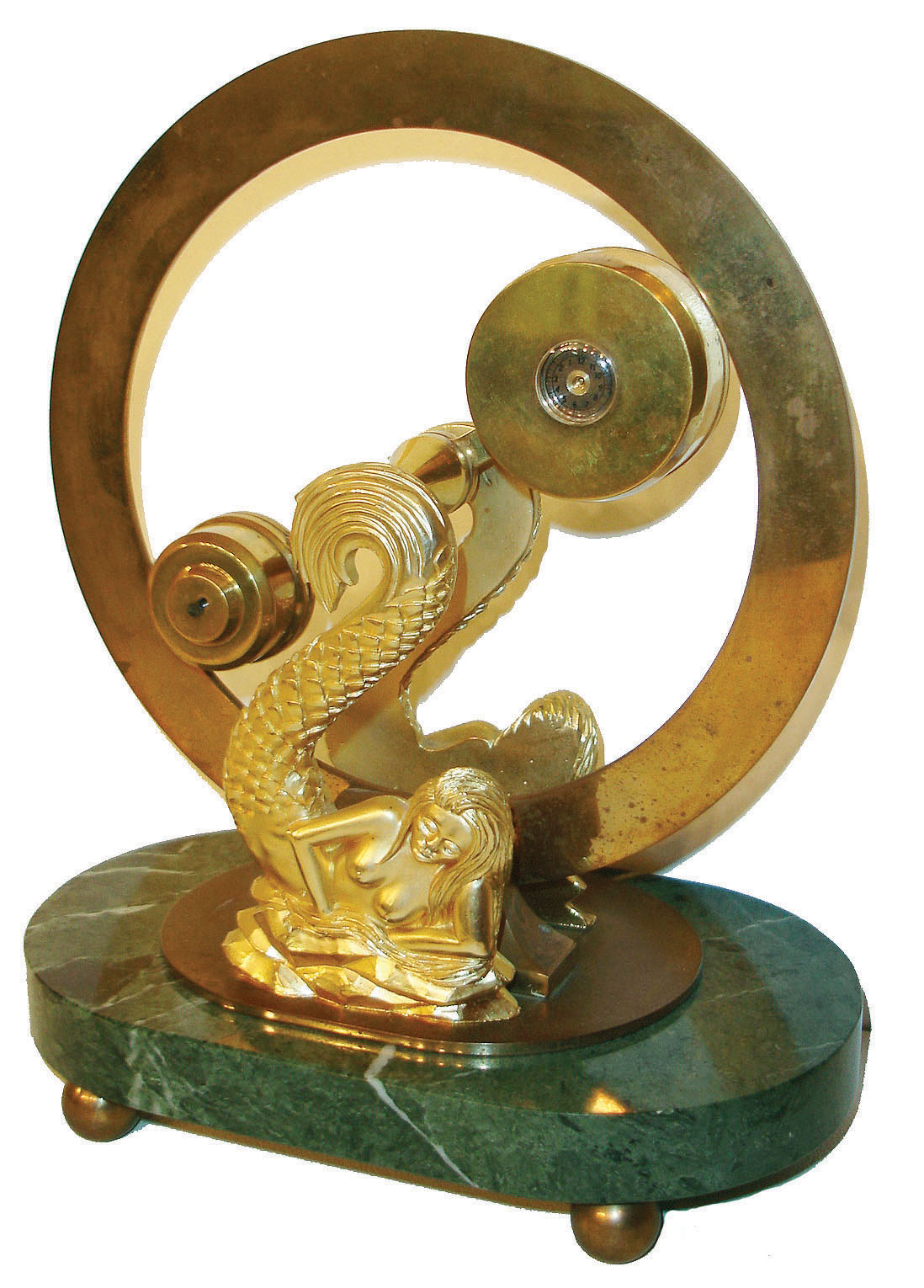 Devon Clocks Ltd., England, mystery clock, design based on John Schmidt's 1808 patent "The Mysterious Circulator or Chronological Equilibrium", the pivoted indicator with a pointer on one end, and the larger cylinder at the other containing the movement with revolving weights, all suspended between two gilt mermaid form supports, Roman numeral silvered chapter ring, on a green marble base with ball feet, base with brass plaque marked "Devon Clocks Ltd. 134/1500, c1980 — Antique Clocks Price Guide