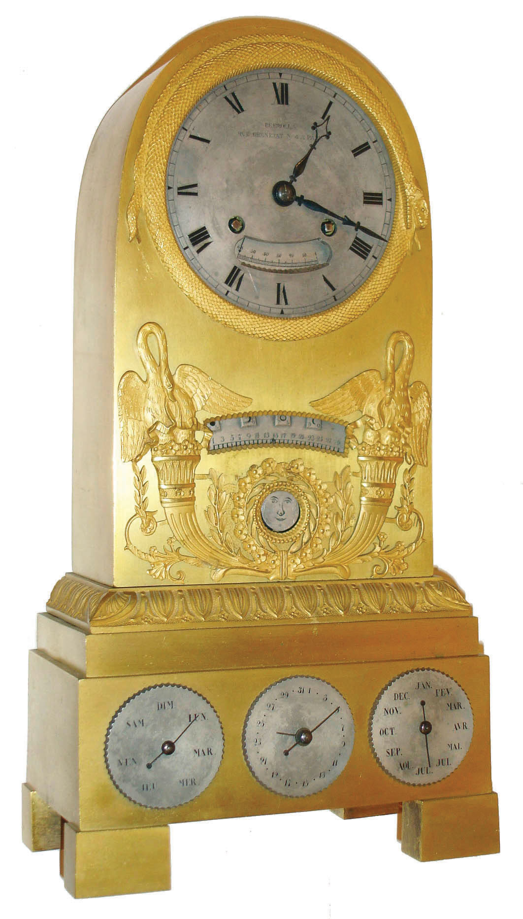 Berrolla, Rue Grenetat N. 4, a Paris, very unusual gilt bronze table or mantel clock with calendar, phases of the moon and retrograde displays, 8 day time and strike pendule a Paris movement signed Pons on front plate, snake form bezel and silvered Roman numeral dial with aperture below center  showing retrograde seconds, aperture in case front with scalloped edge displaying retrograde date, a round aperture below trimmed with gilt leaves and flowers showing phases of the moon, the moon disc painted with a smiling face and backed by a dark blue enamel sky with stars, these displays flanked by swans and cornucopias and other Grecian ornaments, the base with 3 silvered dials with scalloped edges, showing day of the week, date, and month, all dials with blued steel hands, the whole on rectangular feet, c1825 — Antique Clocks Price Guide