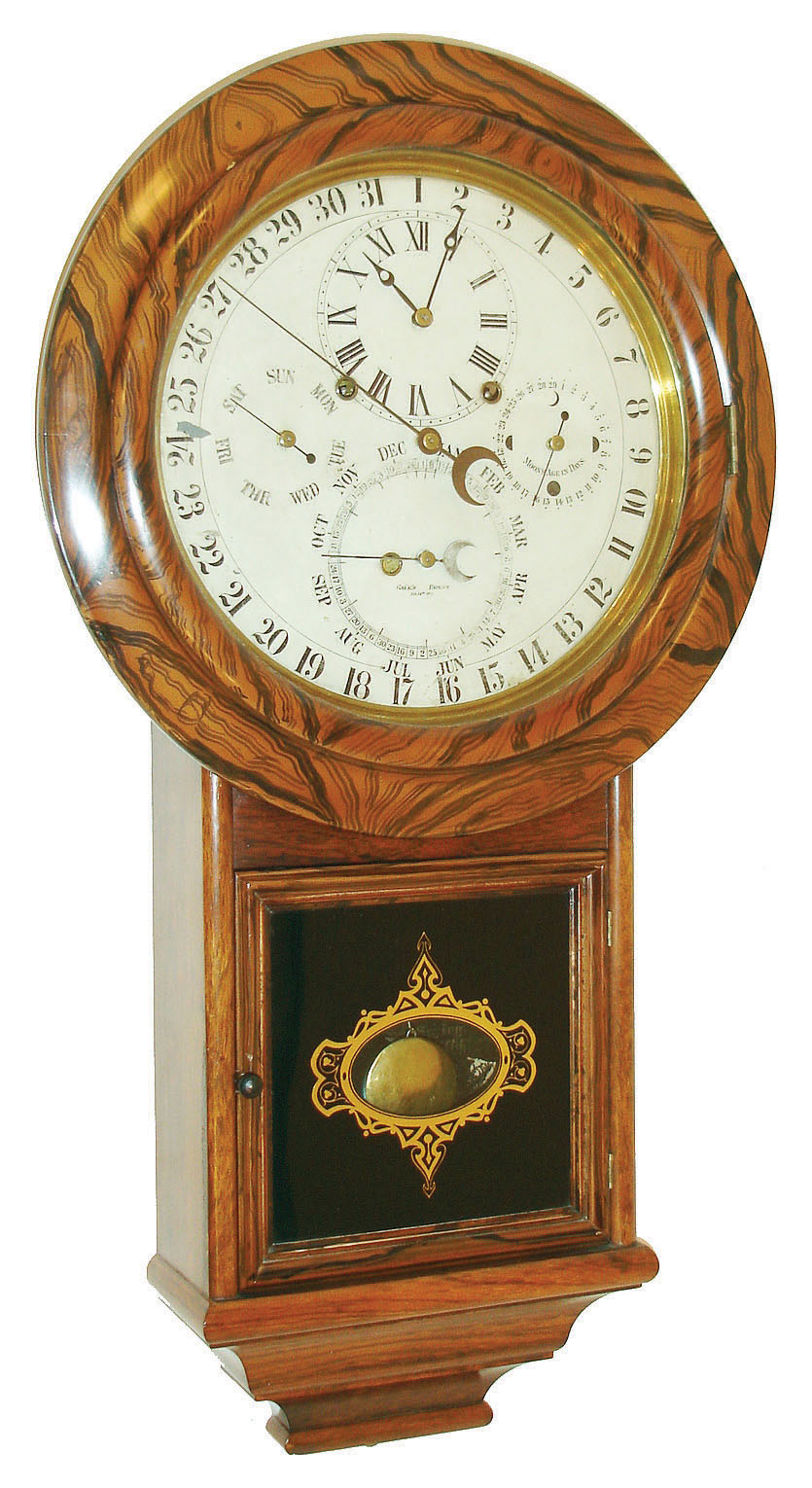 Welch, Spring & Co., Forestville, Conn., "Gale Drop Calendar Model No. 1" wall clock, 8 days, time and strike, spring driven movement with perpetual calendar, patented 1869 and produced from 1871 to 1874.  The movement is housed in a rosewood veneer case with faux rosewood graining around top and a reverse painted lower tablet.  The painted metal dial is marked "GALES PATENT Feb. 14th, 1871", c1871. — Antique Clocks Price Guide