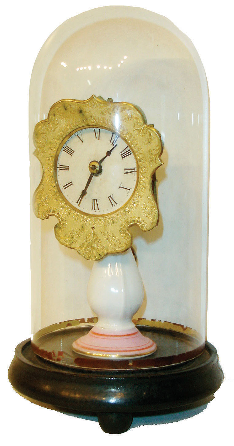 Candlestand clock, porcelain stand with pink band and striping at base, electroformed copper dial surround, Roman numeral white paper dial, steel spade hands, 30 hour timepiece movement, all under a glass dome and mounted to an ebonized, turned wooden base on ball feet, c1860 — Antique Clocks Price Guide