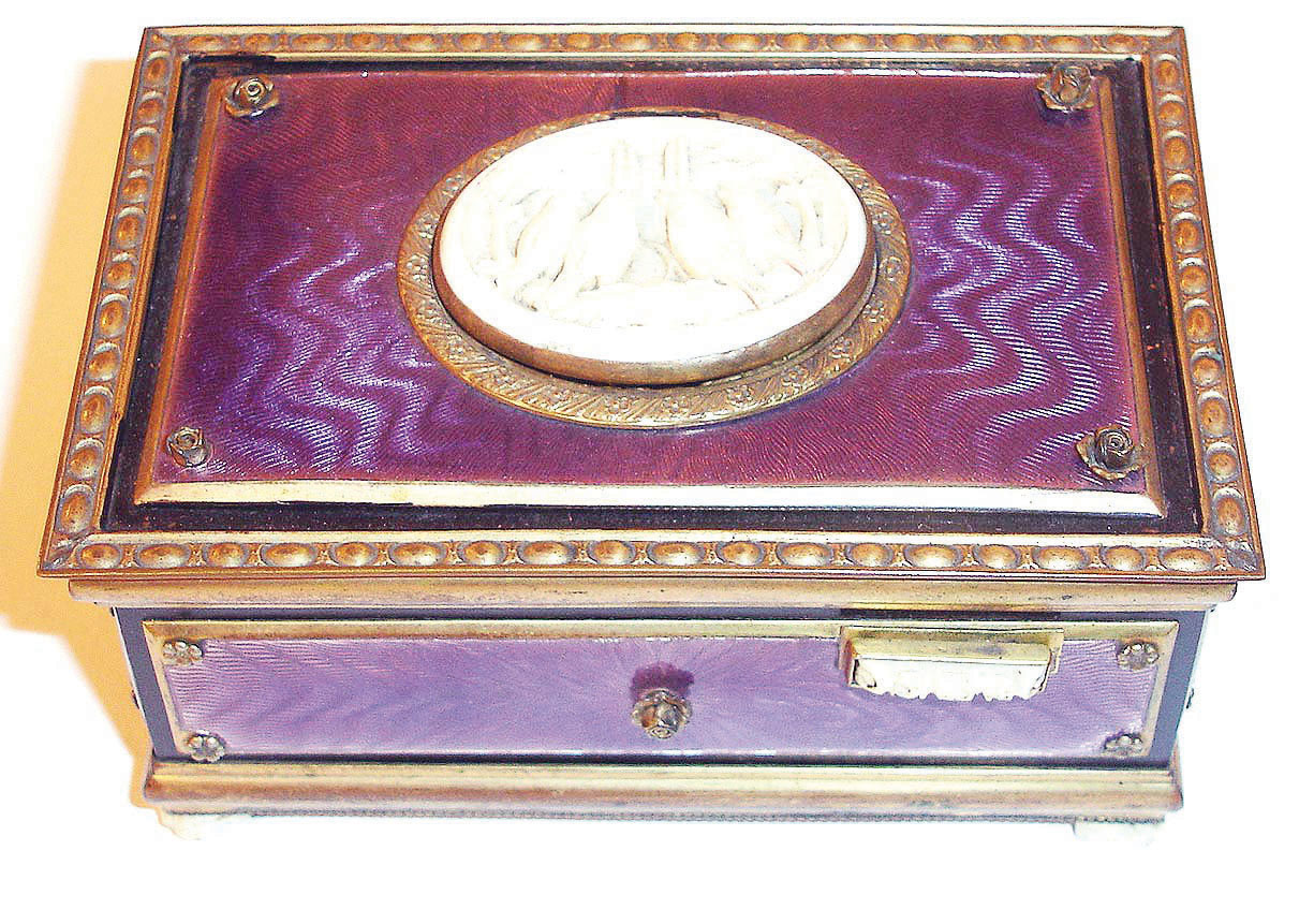 German, Singing Bird Box, key wound, actuated at will with slide on right front of case, the bird singing for his audience and then disappearing from view, from Karl Griesbaum factory, in a light violet guilloche enameled case with a carved ivorene cover over the bird and four ivorene feet, & slide with 4 tiny roses, late 20th century. — Antique Clocks Price Guide