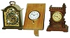 Clocks- 3 (Three) small desk clocks: Austrian castle-form wood 30 hour time only; Swiss Octava 15 jewel 8 day travel clock now in wood stand; Cortland Swiss modern small brass 8 day bracket clock time and alarm, 20th century