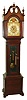 Herschede Clock Co., Cincinnati, Ohio, Colonial style 5 tube hall clock, stamped with maker's details on backboard, 8 days, time, strike and chime, three weight driven German movement playing Westminster tune in a mahogany case with reeded quarter columns on sides, bracket feet and beveled glass trunk. The silvered dial has applied brass Arabic numerals, brass corner and center spandrels and moon phase, c1920