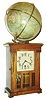 Junghans, Germany, Globe Clock, 8 day time only movement, rectangular walnut case in the arts and crafts style, the door with beveled glasses and simple carving, metal Arabic numeral dial, blued steel hands, the top with 10" terrestrial globe by Ludw. Jul. Heymann, Berlin, the globe geared to the movement and rotating once in 24 hours, c1910