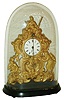 Austria, zappler clock with base and dome, pressed brass case with bright and matte surfaces, decorated with rococo ornament and with three armed male figures, ebonized wooden base on tiny wooden feet, Roman numeral white enamel dial with steel spade hands, 30 hour time only movement with tic-tac escapement and pendulum swinging in front of the dial, all under a glass dome, c1860