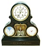 France, monumental black slate mantel clock with perpetual calendar, thermometer and barometer, drumhead case with gilt, incised aesthetic ornament, brass bezel with beveled glass over Roman numeral white enamel dial, Brocot open escapement with carnelian pallets, black painted steel Breguet style hands, enamel perpetual calendar and barometer dials, the calendar with clouds and starry sky, the barometer with red 8 pointed star at center, the central thermometer mounted to a beveled glass with incurved sides and cupids bow top with conforming brass bezel, the thermometer scale engraved on the glass, square 8 day movement marked GV, striking on a bell, rear bezel set with dark violet beveled glass, c1875
