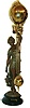 Ansonia Clock Co., Ansonia, New York, "Huntress" figural swinger, the patinated spelter figure of a young woman carrying game birds and holding the clock aloft in her right hand, mounted to an ebonized cast iron base, 8 day time only movement mounted inside a brass sphere with cast ribbon ornament and applied Arabic numerals, Louis XV style hands, the lower section in gridiron style with smaller sphere at the bottom, c1900