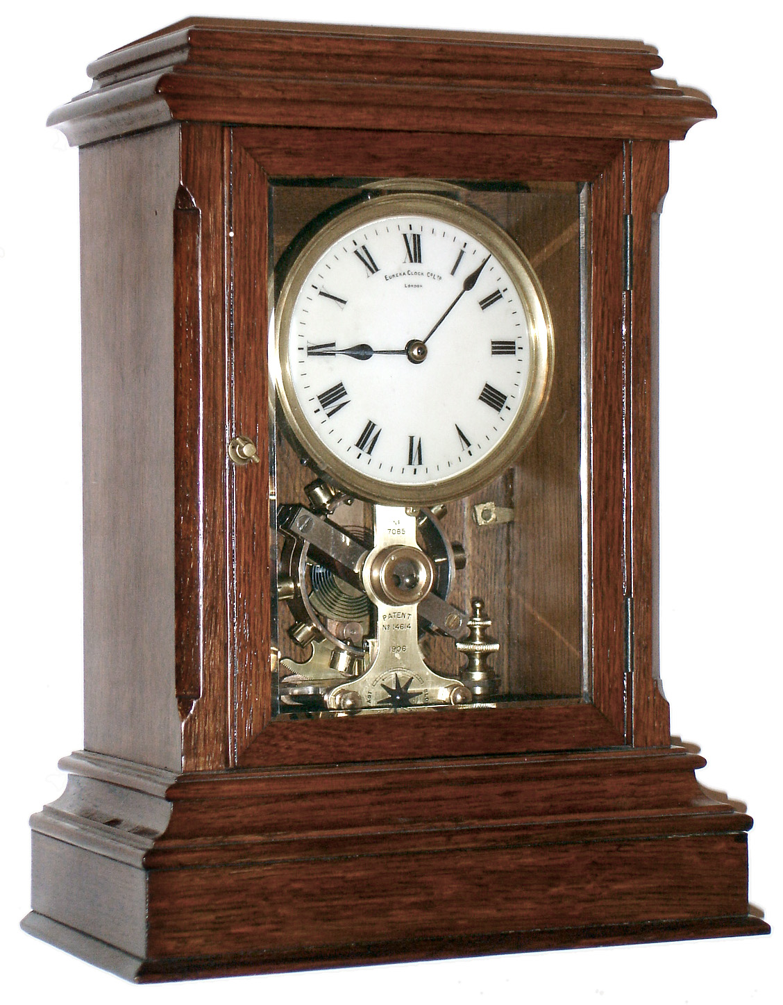 Eureka Clock Co, Ltd, London, England battery powered mantel clock with oversized balance wheel movement in an oak case with beveled glasses and cream enamel dial, c1910 s#7085 — Antique Clocks Price Guide