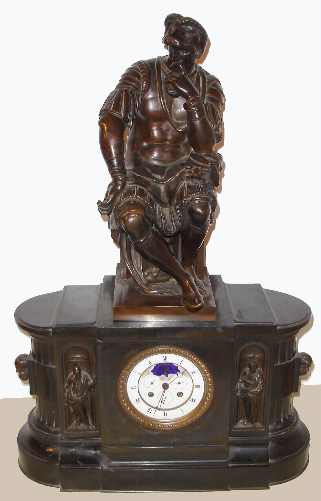 French, Barbedienne, Paris, a large marble and bronze mantel clock with perpetual calendar, and surmounted by a Greek warrior with a lions head helmet, and showing phases of the moon and center seconds, the dial flanked by two robed clerics or philosophers, and the case ends with busts of Socrates on one side and Aristotle on the other. /with damage, c1875 — Antique Clocks Price Guide