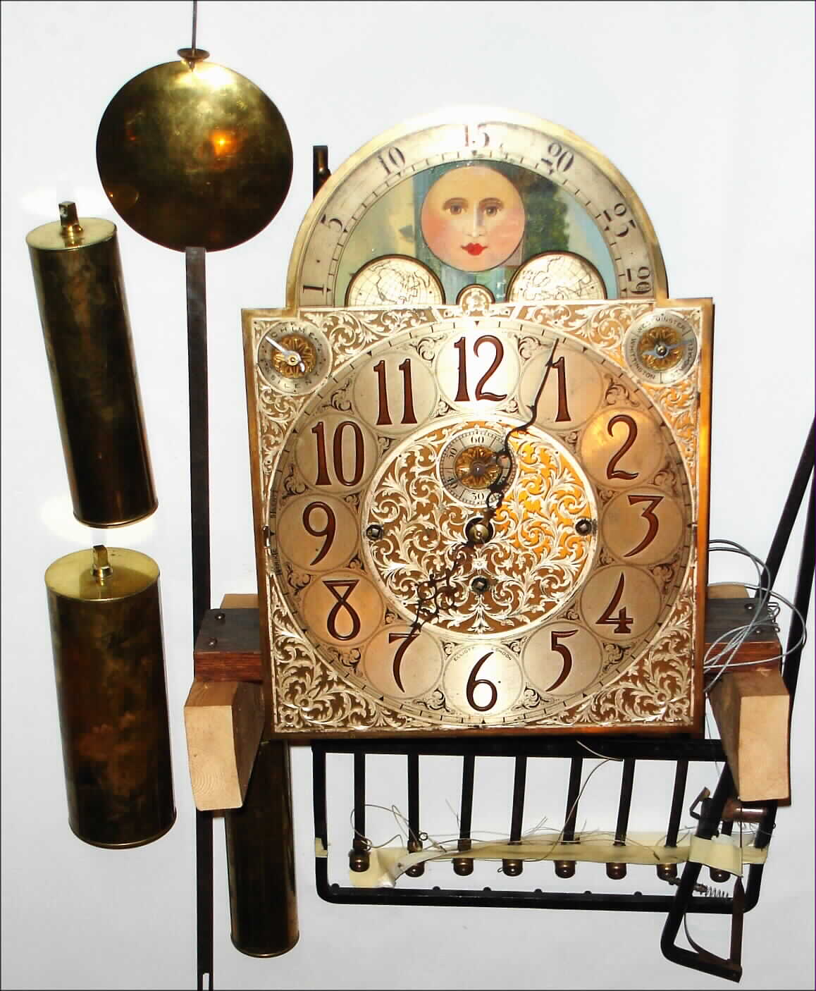 Elliott, London, triple chime long case movement on wood seat board with silvered dial, 3 brass weights, pendulum, and 9 tube rack, c1900 — Antique Clocks Price Guide