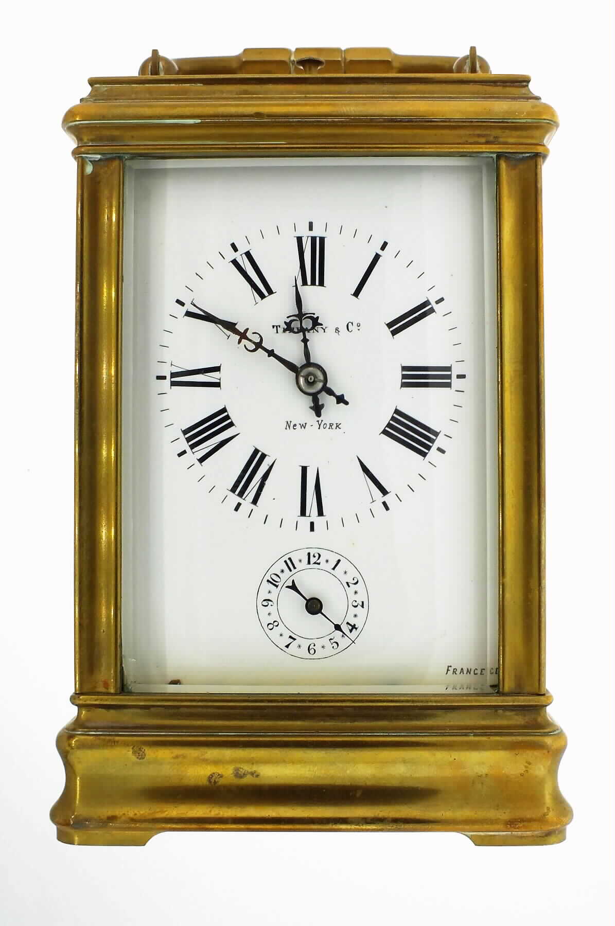 Tiffany and Co., New York, French grand sonnerie repeating carriage clock, spring powered eight day time, strike and alarm movement, with silvered platform lever escapement, sounding the hours and quarters on gongs, polished brass Cannelee variant case, beveled glass sides with oval beveled glass in top for viewing escapement, white enamel dial with Roman numeral Cannelee and Arabic alarm, signed Tiffany and Co., New York, France in lower right corner, blued steel hands, with original leather covered travelling case, c1900 — Antique Clocks Price Guide