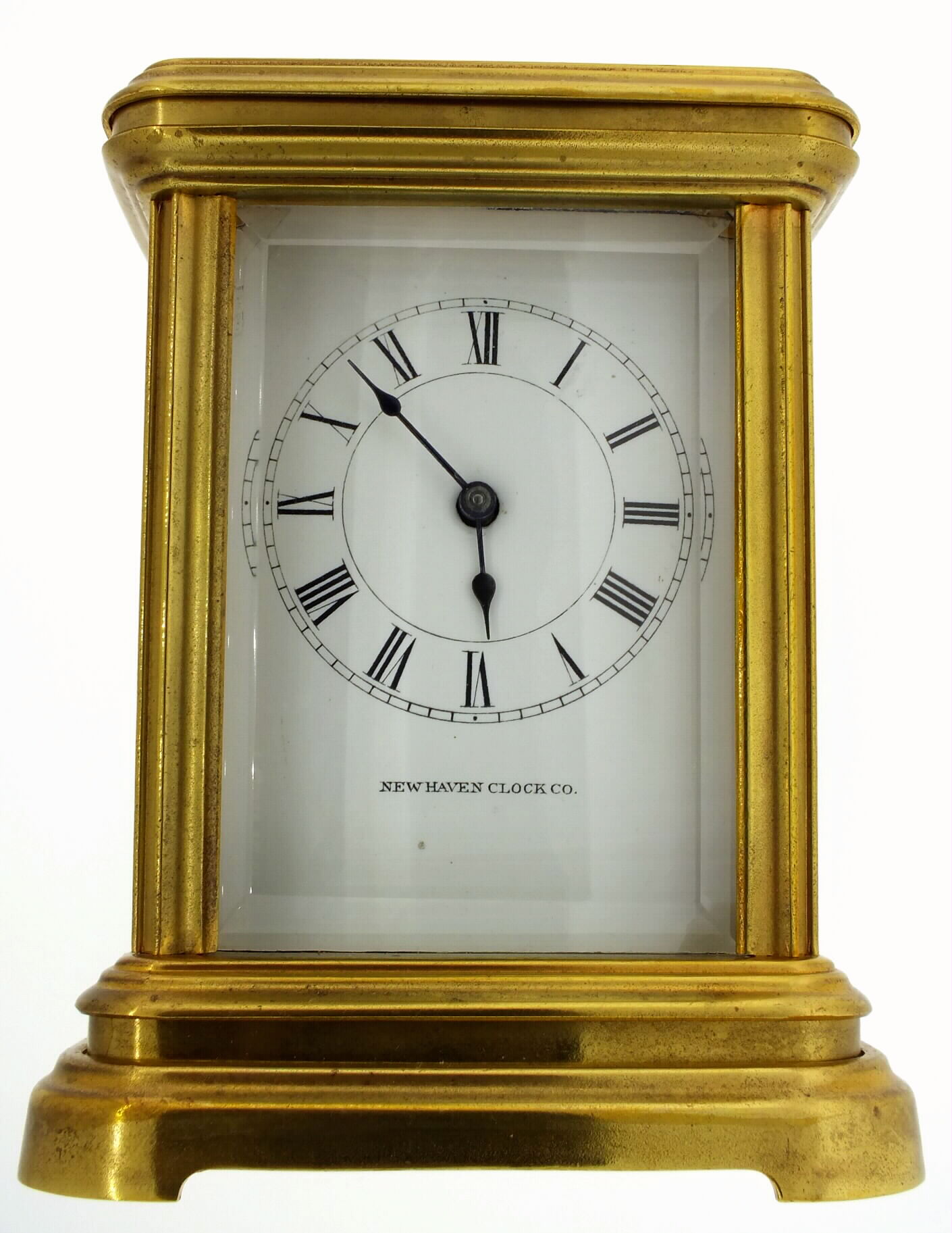 New Haven Clock Co., New Haven, Ct., carriage clock in polished brass case, beveled glass sides and top, spring powered eight day time only movement, with lever escapement, movement train plate with frosted gilt finish, back plate with gilt bright polished and damascene decoration, ratchet wheel cock with decorative engraving, white enamel dial with Roman numerals and signed New Haven Clock Co., blued steel hands, c1885 — Antique Clocks Price Guide