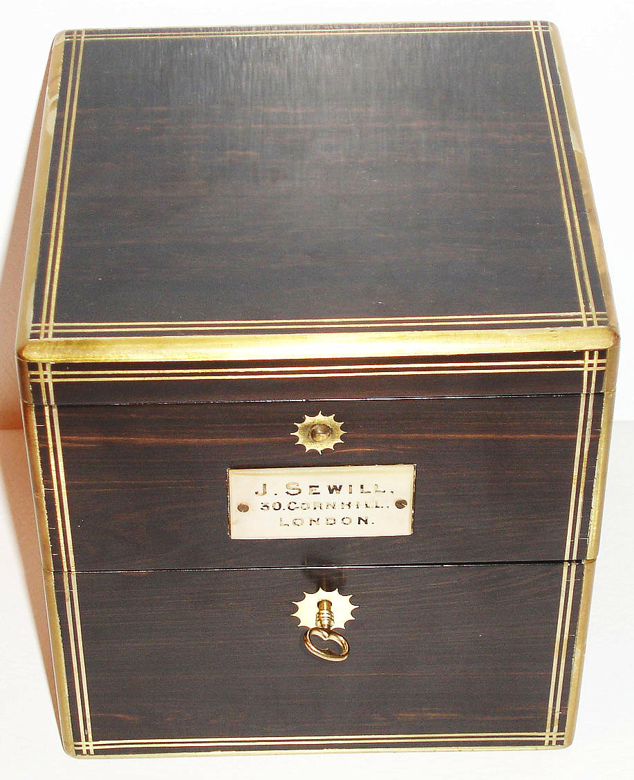 England, chronometer no. 4653 by J. Sewill, London, two day fusee movement with spring detent escapement, chronometer balance with helical hairspring, spotted plates, silvered Roman numeral dial with Arabic five minute markers, up/ down indicator, dial signed J. Sewill, 30 Cornhill, Royal Exchange, London, Maker to the Admiralty, also marked with mention of awards received in London 1862 and Paris 1867, blued steel seconds hand, gold hour and minute hands, lacquered brass bowl in gimbals with locking lever, ratchet type key correct and possibly original, beautiful ebony box with brass binding and hardware, mother of pearl plate on front of box marked J. Sewill 30 Cornhill London c1870 — Antique Clocks Price Guide