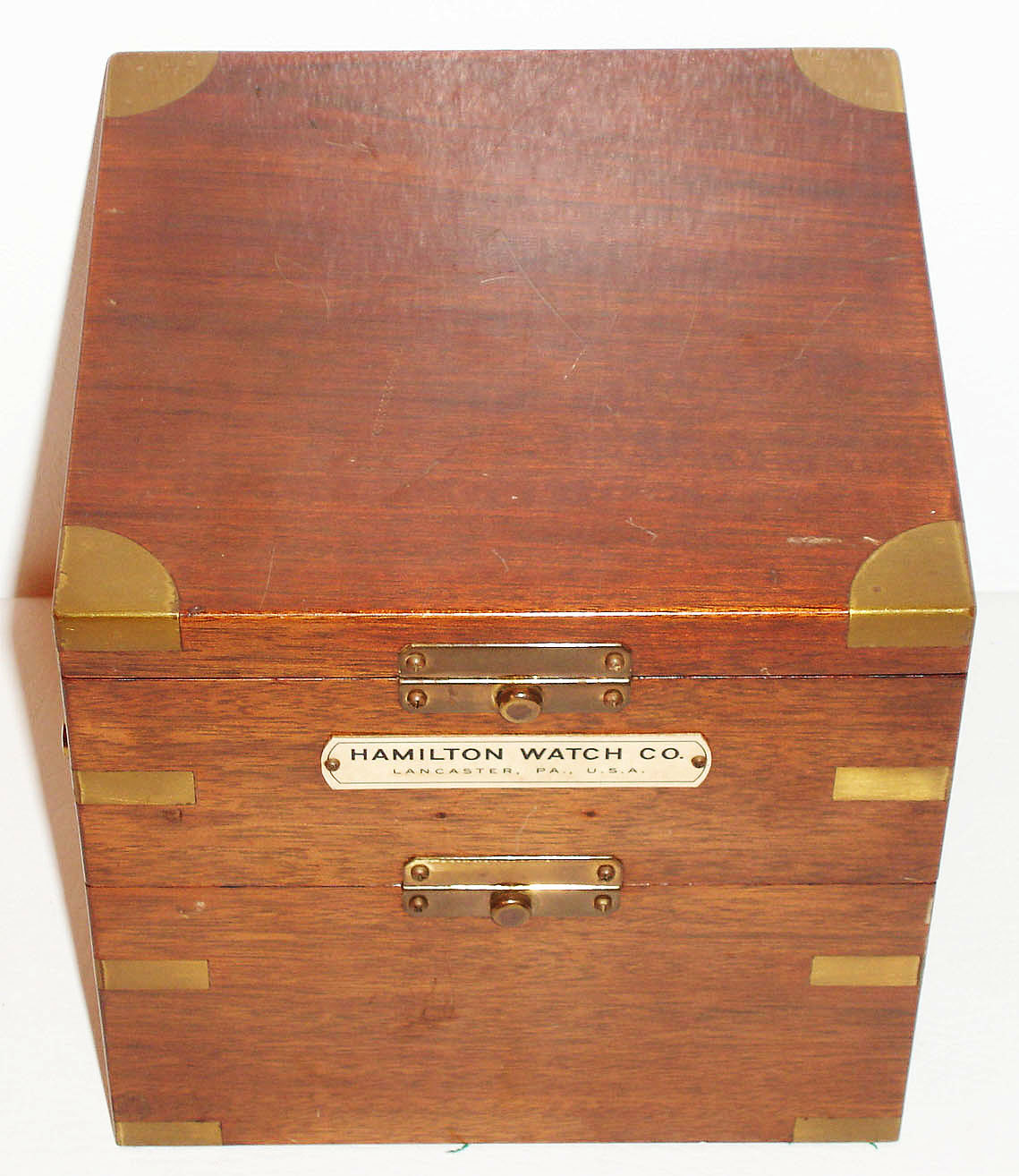 Hamilton Watch Co., Lancaster, Penn., model 21 chronometer no. 4810, key wound, two day, fourteen jewel movement with cotes de Geneve decoration, fusee, spring detent escapement and helical hairspring, matte silver Arabic numeral dial with up/ down indicator, dial signed Hamilton Lancaster Pa., U.S.A., black finished steel hands, original winding key, brass bound mahogany box with gimbals and locking lever, inside of box lid with instructions and illustration of correct way to lock balance, includes Hamilton marine chronometer display card, c1941 — Antique Clocks Price Guide
