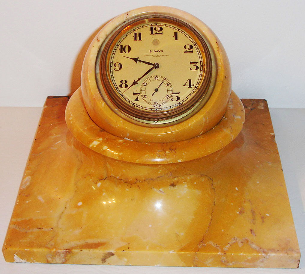 Switzerland, for Greenleaf and Crosby, Zenith rim wind and set eight day time only desk clock in marble case, the gilt movement contained in a marble sphere, the sphere resting in a square marble base allowing the clock to be tilted to any angle, matte gilt Arabic numeral dial marked 8 Days Greenleaf and Crosby Co. Florida, plum colored hands, am/ pm indicator, c1930 — Antique Clocks Price Guide