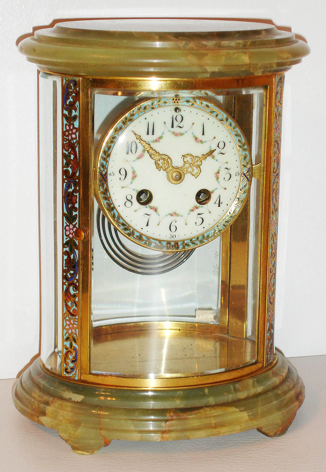 France, 8 day, time and strike, crystal regulator in oval case, Japy Freres movement striking the hours and half hours on a gong, white enamel Arabic numeral dial decorated with floral swags, fancy gilt hands, champleve enamel bezel, case top and bottom of green onyx, with champleve enamel frame, beveled glass panels, c1900 — Antique Clocks Price Guide