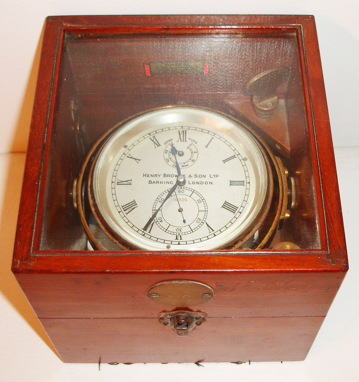 Henry Browne and Sons Ltd., Barking, London, marine chronometer in mahogany box, the 2 day movement with spring detent escapement, cut bimetallic balance with cylindrical weights for temperature compensation, white helical balance spring, spotted gilt plates with blued steel screws, silvered Roman numeral dial with wind indicator and number 16926, blued steel hands, brass bezel with beveled glass, lacquered brass bowl and hardware, mahogany box with glazed top, brass tag showing chronometer number, with key c1910 — Antique Clocks Price Guide