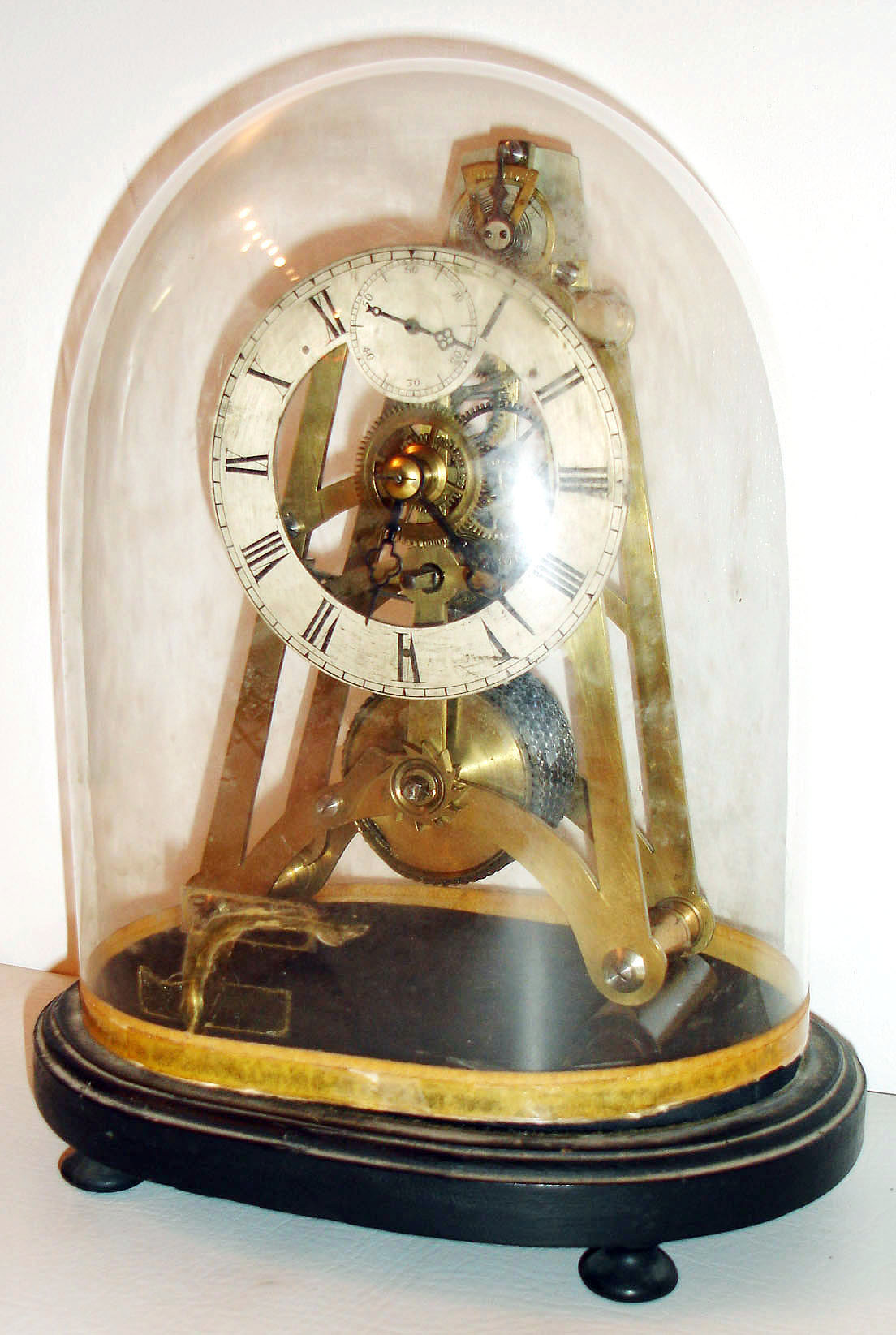 English fusee skeleton clock with platform escapement, polished A frame plates with 4 bold baluster form pillars, vertically mounted silvered platform with duplex escapement marked "Philcox 277 Patent", the brass balance with blued steel spring, silvered Roman numeral dial with seconds at 12:00, blued steel hands, mounted on a black painted velvet covered base, and covered by a conforming glass dome, c1850 — Antique Clocks Price Guide