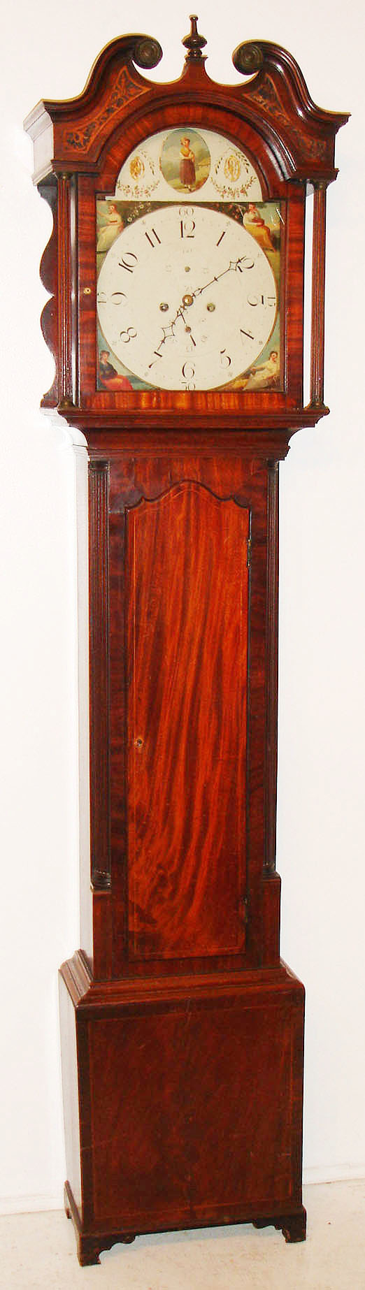 Scottish tall clock, 8 day, time and bell strike, weight driven movement in a mahogany and mahogany veneer case with sting inlay around the door and plinth, reticulated inlay in the broken arch of the hood, reeded columns on hood and reeded half columns on the trunk and painted iron dial depicting seasons in the spandrels, c1830 — Antique Clocks Price Guide