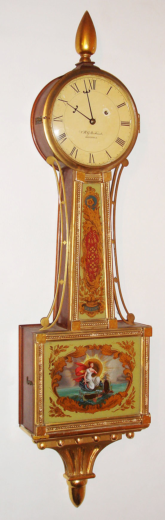V.H.G. Wadlund, Broomall, 8 day, reproduction banjo or patent timepiece.  Broomall is place in Pennsylvania and there is a Mr. Wadlund who lives in Broomall, so we assume he made this timepiece.  The case is marked no. 15.  c. 1959 — Antique Clocks Price Guide