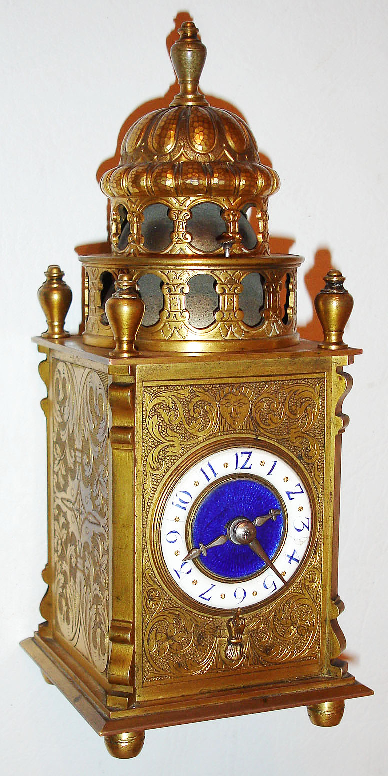 France, grand sonnerie striking desk or table clock, the engraved and gilt case in the style of early 17th century German work, French eight day time and strike carriage clock movement, striking and repeating on gongs, with lever platform escapement, white enamel Arabic numeral dial with blue enamel center, steel hands, back of case marked "Planchon au Palais Royal", sonnerie/ silence controlled by lever under case, c1910 — Antique Clocks Price Guide
