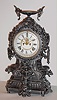 Ansonia Clock Co., New York, NY, "FRANCONIA", cast metal fantasy clock, featuring flying gargoyles to the sides, a bird below the dial and profuse scrolls and swirls, surmounted by a winged urn, c1894.