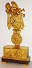 French mantel clock, 8 day, time and strike, pendule a Paris movement, with recoil escapement and count wheel, signed "Chappe a Paris", the gilt bronze case with winged figure, holding drapes on either side of the gilt Roman numeral dial with grape and leaf ornament, blued steel Breguet style hands, simulated gridiron pendulum in gilt bronze and polished steel, pendulum also with grapes and leaves theme surrounding a female bust, the base with reclining winged figure, a pair of doves, and more grapes, on a red patinated plinth supported by palm decorated gilt feet, c1825,