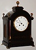 French shelf or bracket clock in the Regency style, 8 day pendule a Paris movement, recoil escapement and rack striking on a gong, white enamel Arabic numeral dial, blued steel Breguet style hands, polished brass bezel with convex beveled glass, case of mahogany and mahogany veneer with brass inlay, feet, and finials, and pierced brass fabric covered frets in each side, c1890
