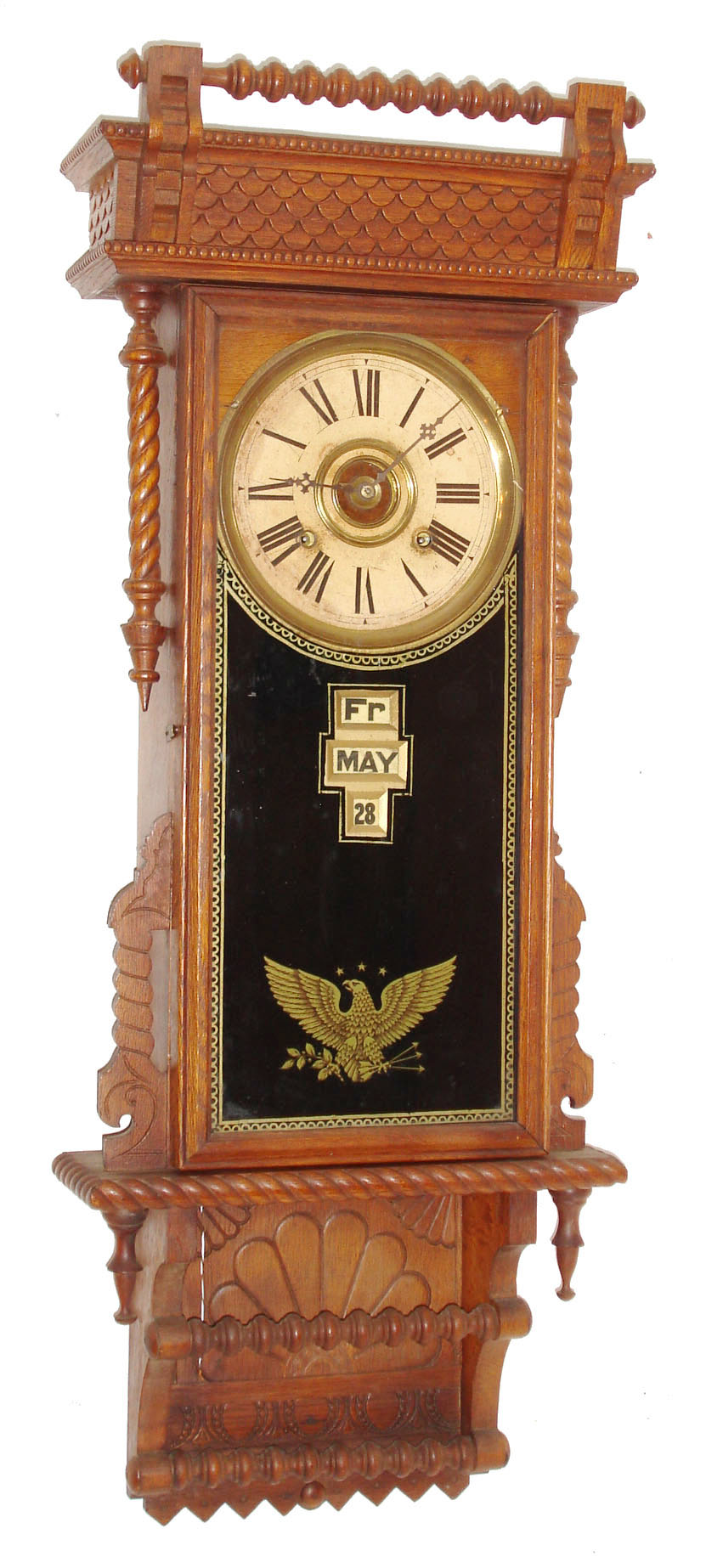 William L. Gilbert Clock Co., Winsted, Conn., "Sharon", wall clock, 8 days, time, strike and McCabe's patent with digital calendar, spring driven movement in an oak case with reverse painted tablet and papered metal dial, c1890 — Antique Clocks Price Guide