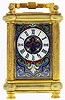 French miniature carriage clock for Payne & Co. 163 New Bond St., London, 8 day, time only, spring driven movement with lever platform escapement in a gilt case with reeded columns and turned feet and inset with two cloissone enamel panels and a cloissone enamel mask surrounding Roman numeral white enamel dial, serial #7447, c1885