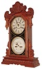 Waterbury Clock Co., Waterbury, Conn., "Oswego" 8 day, time and strike, double dial gingerbread style calendar clock. We could not find this example in the catalog. There is a partial label on the back that reads "American Manufacturing-" .  This model was most likely made for them.   c1900