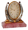 Desk or nightstand clock, polished rose quartz base supporting a silvered horseshoe with gilt nails, and an oval framed, silvered dial clock with gilt Arabic numerals, the dial signed "Charlton & Co. 8 days, Swiss" with gilt, luminous hands, nickel 15 jewel movement signed "Concord Watch Co", c1920
