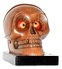Germany, possibly Oswald, "Skull" rotating eye novelty clock, the brown composition skull with 30 hours, time only, movement, red and yellow eyes, the back marked "Patented U.S.A. Aug. 31 1926 Made in Germany No Jewels", on a polished ebonized base, c1930
