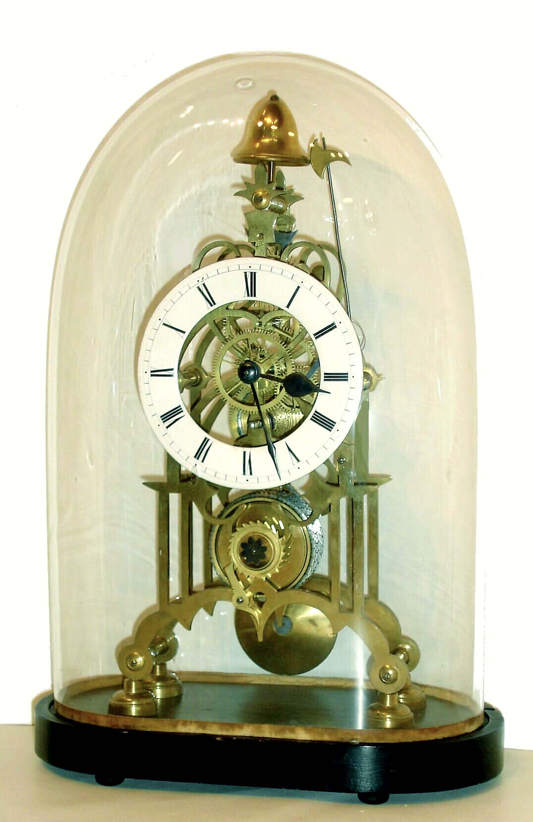 English, attributed to W. F. Evans, a single chain fusee skeleton clock, striking a single bell tone at the hour, and with optional white porcelain enamel dial {that makes reading the time much easier}, mounted to an oval wooden base, and with old /period glass dome, c1870 — Antique Clocks Price Guide